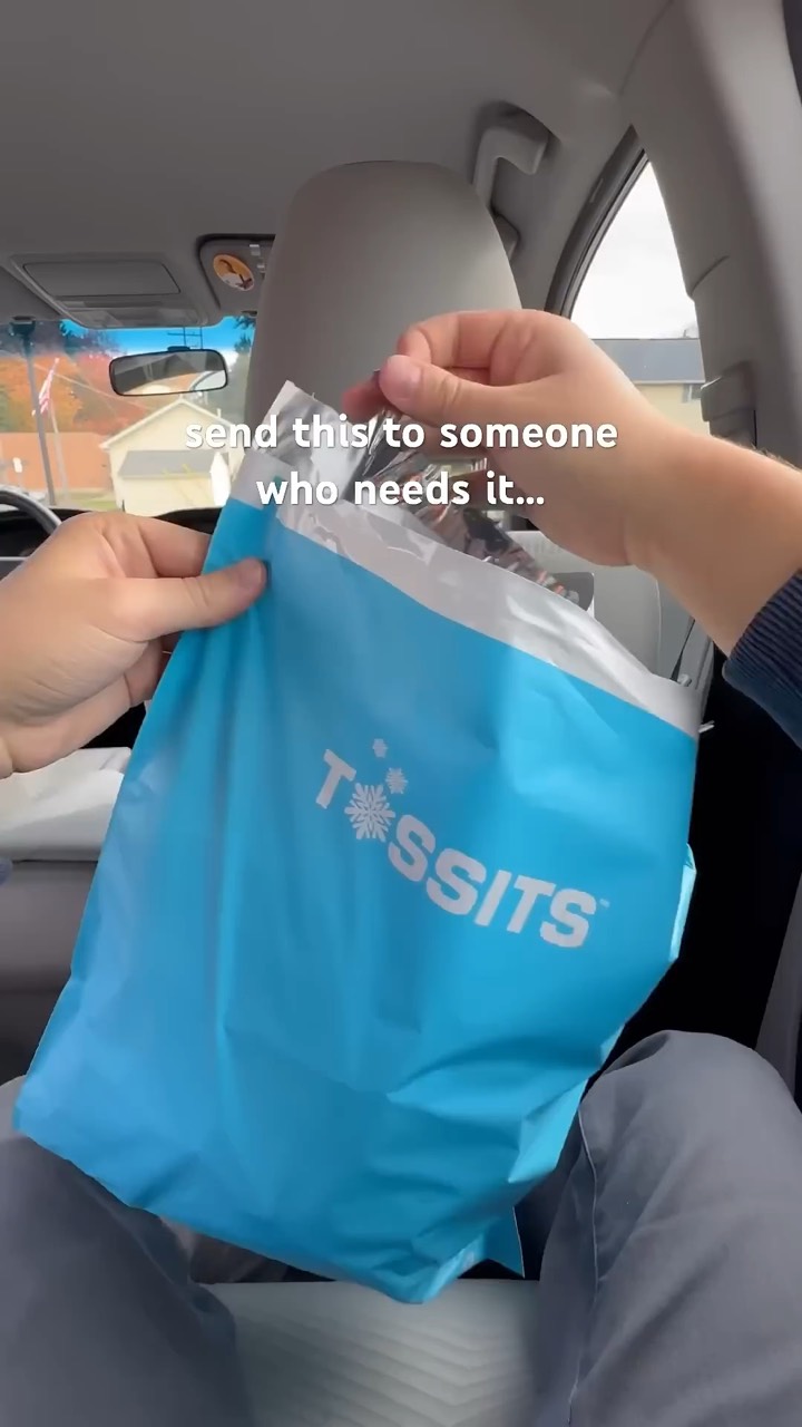 Hands open a blue Tossits bag on the back of a car seat
